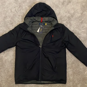 Ralph lauren jacka Ny! - Tja. Säljer denna sprillans nya Ralph lauren jacka i storlek M och färg marinblå. FJackan passar perfekt nu när de blir lite varmare ute men fortfarande är kyligt. Den är matt på insidan och fodrad på utsidan vilket gör den väldigt unik. Pris 1995