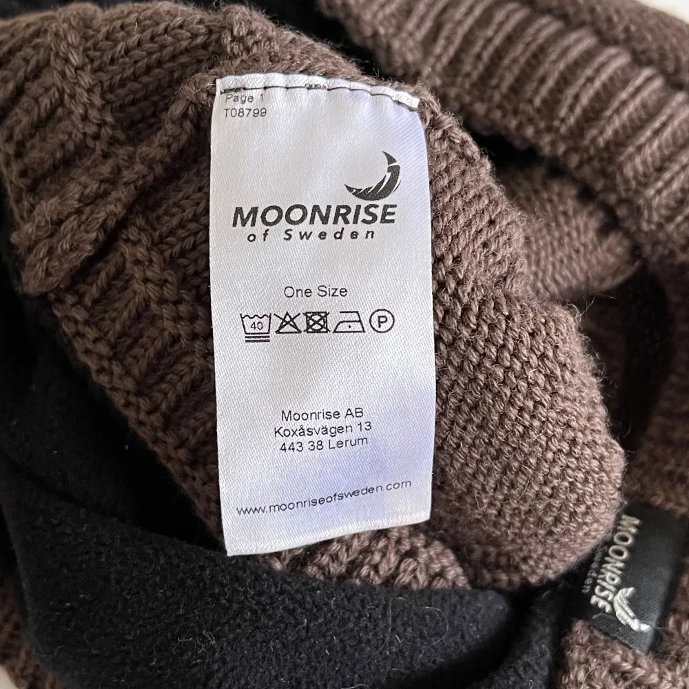 Brun mössa från Moonrise med hål för tofs i merino/akryl. Superfin mössa som passar både stora och små. Den har endast använts någon enstaka gång så den är i nyskick.. Accessoarer.