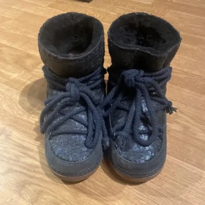 Blå Inuikii - Mörkblå inuikiis med plajetter i storlek 37. Knappt användna, de är i nyskick. 