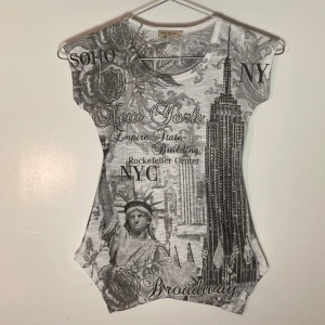 Kort tajt New York meshtopp med snyggt tryck och spetsig stjärning - Favorit tröjan men har växt ur. Supernsygg unik tröja med svartvitt mönster fram och back. Tröjan har framtill en stjärning i två spetsar. Tröjan är kort och tajt så sotter perfekt med lågmidjade jeans. Storlek S