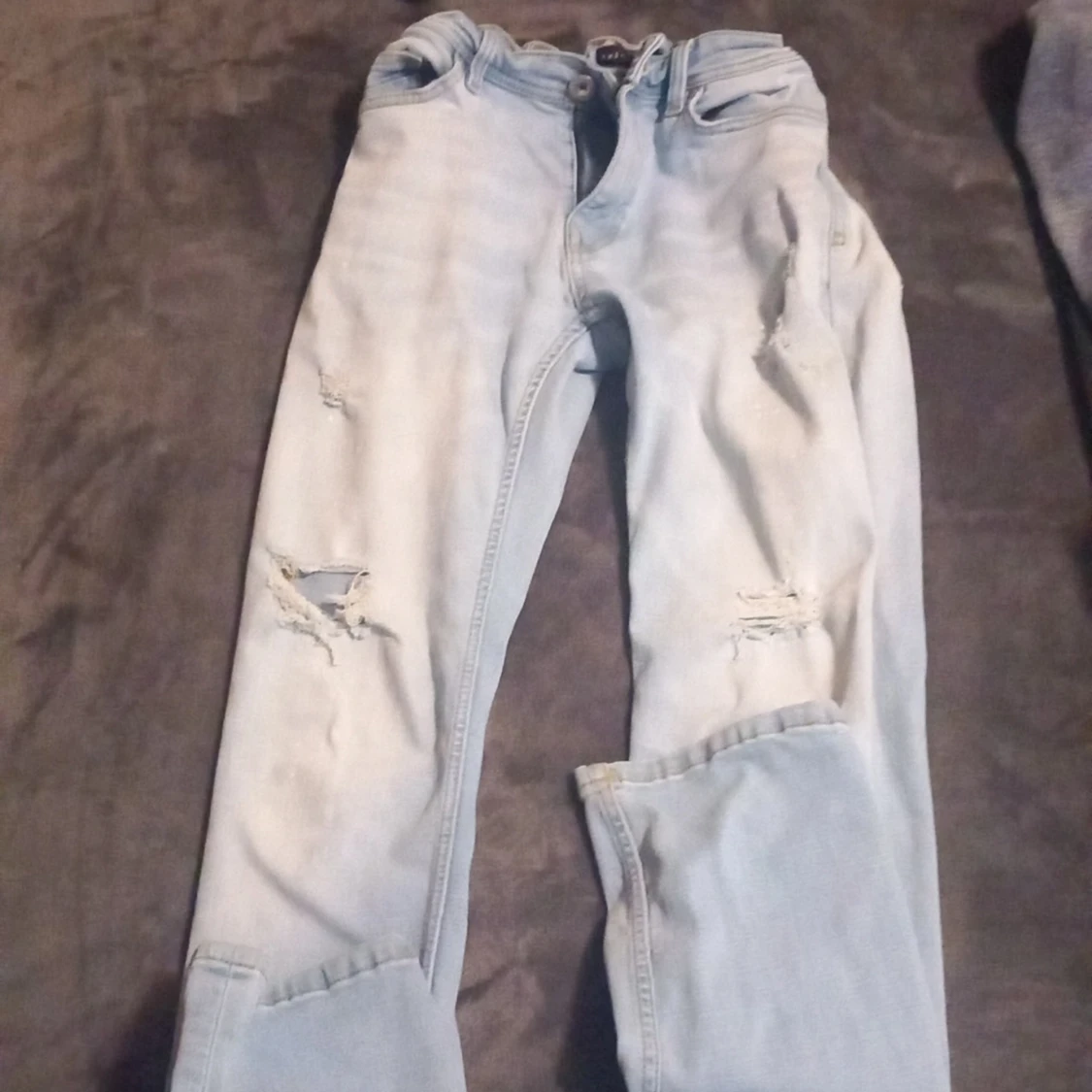 Ljusblå jeans med slitningar