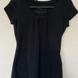 Svart kortärmad topp från Esprit - Säljer en stilren svart vintage topp från Esprit. Den har korta ärmar och en rund halsringning. Perfekt för både vardag och fest! 🖤