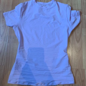 Tight SKIMS tröja - Helt oanvänd Skims tröja i färgen Lily (ljus lila/rosa).Tröjan är i storlek S. Materialet är lätt och tunt. Färgen på tröjan liknar mest den på 4 bilden.  Originalpris är 656kr.