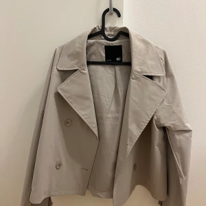Kort trench jacka - Kort trench jacka från Lager 157. Inte använt en endaste gång. Jätte fin beige färg som är neutral. 