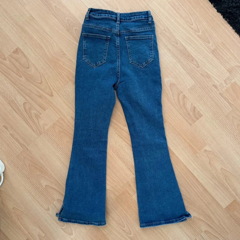 Snygga blå bootcut jeans i nyskick för ca 12-14år beroende på hur stor du är. Stl 146 i byxan.  Längd 99cm. Midja 67cm. Höft 88cm. Högmidjade. Slits vid benen. Hämtas på Hägerstensåsen eller ök 💙. Jeans & Byxor.