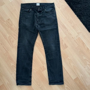 Svarta jeans från Denim Demon - Svarta jeans från Denim Demon i storlek W34 L32. De är tillverkade av 99% bomull och 1% elastan, vilket ger en skön passform. Byxorna har en klassisk femficksdesign och är något sliten vid grenen. Hämtas på Hägerstensåsen eller ök ♣️