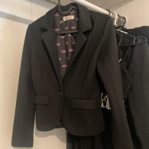 Kavaj - Svart kavaj från H&M med mönster innuti. Tyget är lite mjukare än vanligt kostym material. Skulle även säga att den är rätt så figursydd!