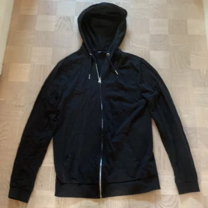Svart zip hoodie - Säljer en svart zip hoodie från ASOS i storlek xs men passar även storlek s. Den har en dragkedja framtill och en mysig huva. Perfekt för både vardag och chill hemma. Tröjan är i bra skick och passar till det mesta. Hör av dig vid intresse!