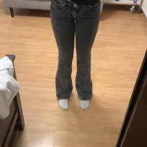Gråa bootcut jeans - Snygga gråa bootcut jeans med låg midja. Perfekta för en avslappnad stil. De har klassisk femficksdesign och stängs med dragkedja och knapp.