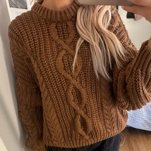 Brun kabelstickad tröja - Mysig brun kabelstickad tröja från Gina Tricot i storlek M. Den är super skön att ha på sig och passar perfekt nu under kyligare dagar. Inga synliga defekter, mycket bra skick