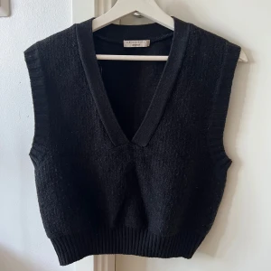 Stickad väst Gina tricot - Snygg svart stickad väst från Gina tricot med v-ringad design. Perfekt för lager-på-lager-stil och passar till både skjorta och t-shirt. Ribbad nederkant ger en stilren look. 