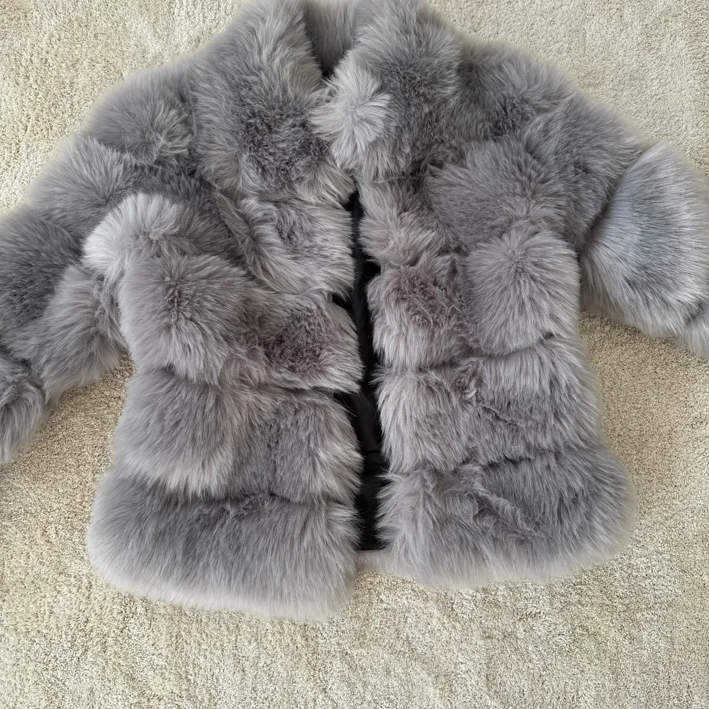 Säljer en lyxig och fluffig grå pälsjacka från Dennis Maglic. Jackan har en elegant design med långa ärmar och är perfekt för att hålla dig varm och stilren under kyliga dagar.. Takit.