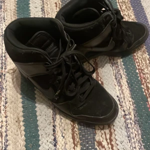 Isabel marant liknanden Nike  - Säljer ett par svarta Nike sneakers med snörning. Skorna har en högre modell med inbyggd kilklack och är perfekta för en sportig look. De har en klassisk Nike-logga på sidan. Liknar lite isabel marant skor!!!