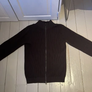 Brun stickad tröja från John Henric - Säljer en stilren ziptröja från John Henric i kashmir blandning. Väldigt skön varm tröja som knappt är använd. Perfekt att ha på våren, hösten och vintern. Köpt för 1000kr