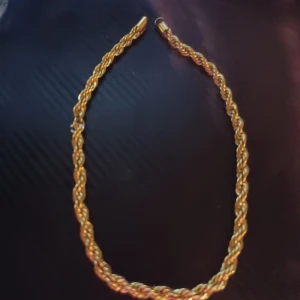 Guldigt flätat halsband - Elegant guldigt halsband med en flätad design. Perfekt för att ge en touch av glamour till din outfit. Passar både till vardag och speciella tillfällen.