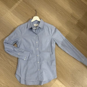 Blå skjorta från Holly & Whyte - Snygg blå skjorta från Holly & Whyte by Lindex. Skjortan har långa ärmar och knappar framtill. Snygg passform. 98% Bomull o 2% Elastan. 