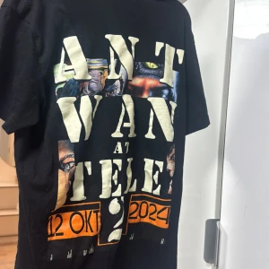 Svart t-shirt med Antwan text  - Cool svart t-shirt med stort text på framsidan och text på baksidan Antwan . Designen inkluderar datum och plats för ett evenemang. Perfekt för dig som gillar unika och stilrena plagg.