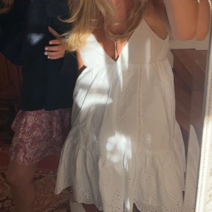 ZARA klänning - Populär Klänning från Zara.  vit klänning med broderade detaljer och djup v-ringning. Den är ärmlös och har en luftig passform, perfekt för varma dagar. 