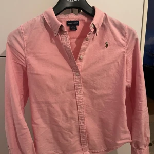 Rosa skjorta från Ralph Lauren - Rosa skjorta från Ralph Lauren. Knappt använd, och sitter lika bra på xs. 