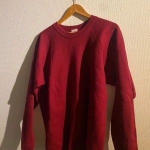 Röd tröja i bomull och polyester - Säljer en röd tröja i storlek XL, tillverkad av 50% bomull och 50% polyester. Tröjan har en klassisk design med långa ärmar och rund halsringning. Perfekt för en avslappnad stil.
