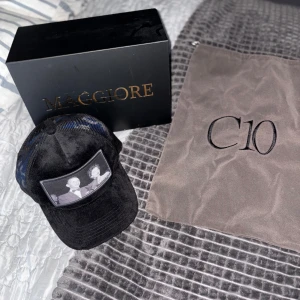 Svart keps från maggiore (Limited edition) - Snygg svart keps med ett unikt tryck på framsidan. Perfekt för en cool och avslappnad stil. Kommer i en stilren förpackning. Kepsen är ifrån s2. Har aldrig använt kepsen. det är svart mocka på kepsen hör av er vid minsta fundering. Mvh Charlie. ( Ny pris på denna är 1000