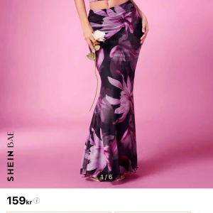 Blommigt sett från SHEIN BAE - Trendig sett med blommigt mönster i lila och rosa nyanser. Toppen har smala axelband och en draperad design framtill, perfekt för en somrig look. Kjolen är helt ny och toppen endast använd ett fåtal gånger🖤