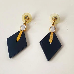 Svarta och guldiga örhängen med kristalldetalj - Snygga vintage örhängen i svart och guld med en elegant kristalldetalj. De har en geometrisk form som ger en modern touch. Perfekta för att lyfta vilken outfit som helst.