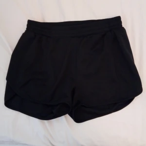 Svarta träningsshorts från SOC - Säljer ett par svarta träningsshorts från SOC. De är designade för att hålla dig torr och bekväm under träning med TCS Airflow-teknik. Perfekta för sportiga aktiviteter!