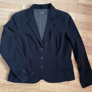 Kavaj från Alice Bizou - Snygg och välsydd kavaj från Alice Bizous. Två falska fickor på framsidan som dekoration. Välsydda sömmar och en falsk omlott på ryggen ger en exklusiv look. Storlek 46 men jag tycker att den är liten i storleken