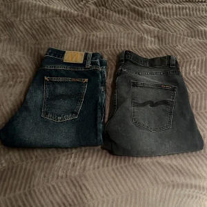 Två par jeans från Nudie Jeans - Säljer två par jeans från Nudie. Båda är i ganska bra skick, de svarta jeansen är i storlek 33/32 och de blåa i 32/32. Båda säljs för 1000 kr.