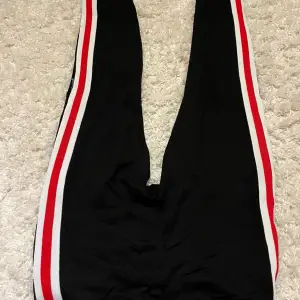 Ett par slim, svarta mjukis byxor med snygga rödvita ränder på sidorna! Använt fåtal gånger.