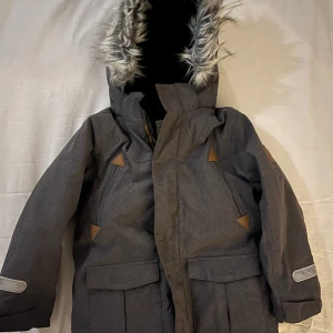 Mycket fin vinterjacka frqån PoP! - Mkt fin vinterjacka i stl 110 från Polarn o Pyret ! Varmt vadderad med fleecefoder och avtagbar luva. Mkt fin skick, endast använd av ett barn. Namnad på lapp i insidan vid nacken.