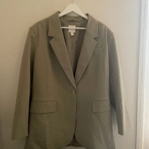 Oversized kavaj - Olivgrön oversized kavaj. Använt 2-3 gånger. Storlek M, känns mer som en L i passformen. Är i ett fint skick. 