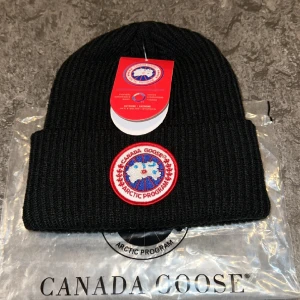 Canada Goose Beanie - Hej! Säljer en helt ny canada goose mössa. Sitter tajt och är rätt så liten.  Inte använd och stilren. Håller dig varm, vid snabb affär kan jag även gå ner i pris! 