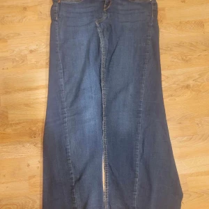 Lång jeanskjol  - Jeanskjol omsydd av jeansbyxor från Gina Tricot. Mörkblå stretch. Slits fram och baktill. Står storlek XL i den men uppskattas som en M eller L . Total längd: 100cm , midjan bredd: 42.  Personen på bilden är ca 168cm 