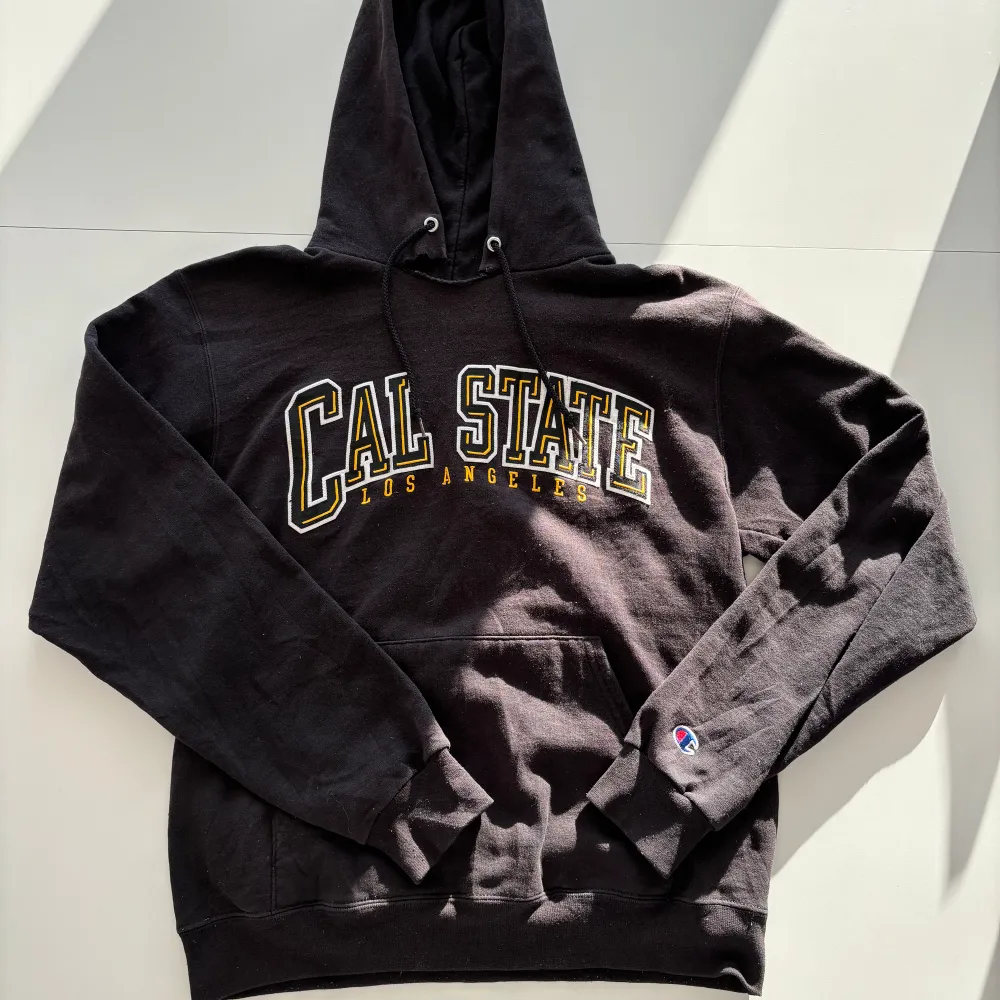 Säljer en superfin svart hoodie från Champion med Cal State tryck. Svart färg! Storlek S. Hoodies.