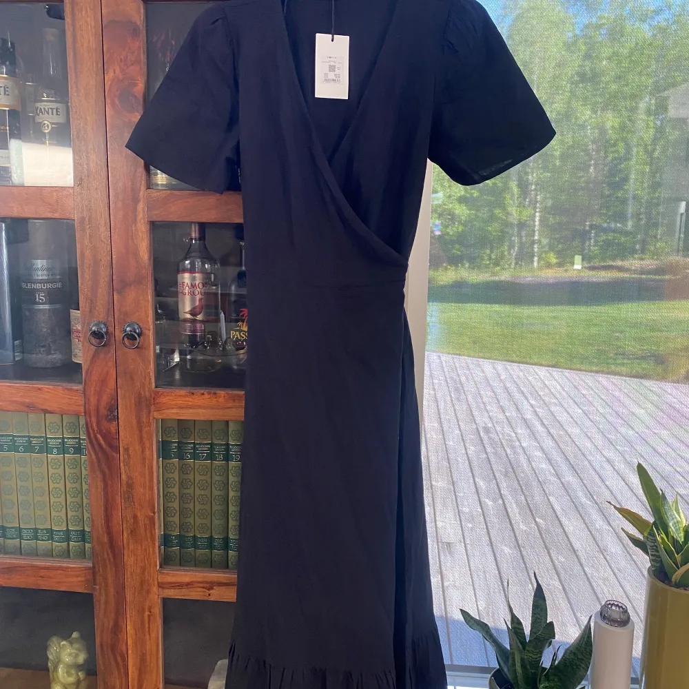 En SUPER!!!fin svart långklänning! Den är omlott med snörning i midjan. Jag är 172 och den går nästan ner till fötterna 🤩. Helt ny med prislapp! Säljer pga tyckte den var för stor.  DRÖM klänning om du frågar mig😍❤️‍🔥Nypris 699kr. Klänningar.