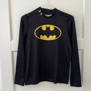 Batman Under Armour träningströja - Träningströja från Under Armour med Batman tryck. Storlek S och passar nog XS också