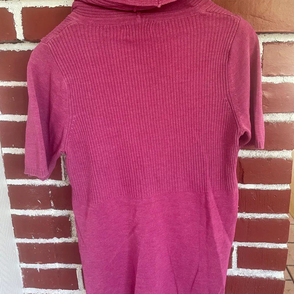 Stickad, rosa tröja med korta ärmar och vid polokrage.  Cappuccini  Stl M. Stickat.