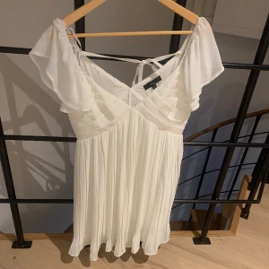Vit klänning/studentklänning  - Säljer denna superfina helt oanvända vita klänning som passar perfekt nu till student tider. Klänningen är inköpt på lulus nypris var 1100 kr. Ryggen är lite öppen och har en rosett man knyter se bild 2. Storlek är M men den sitter som en S❤️
