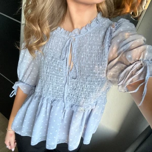 Blus med volang - Ljus blå blus med volang nedtill med knytning vid armarna och upptill❣️❣️