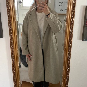 vero moda kappa - lång kappa från vero moda, använd 1 gång så den är helt som ny. bälte i midjan. beige