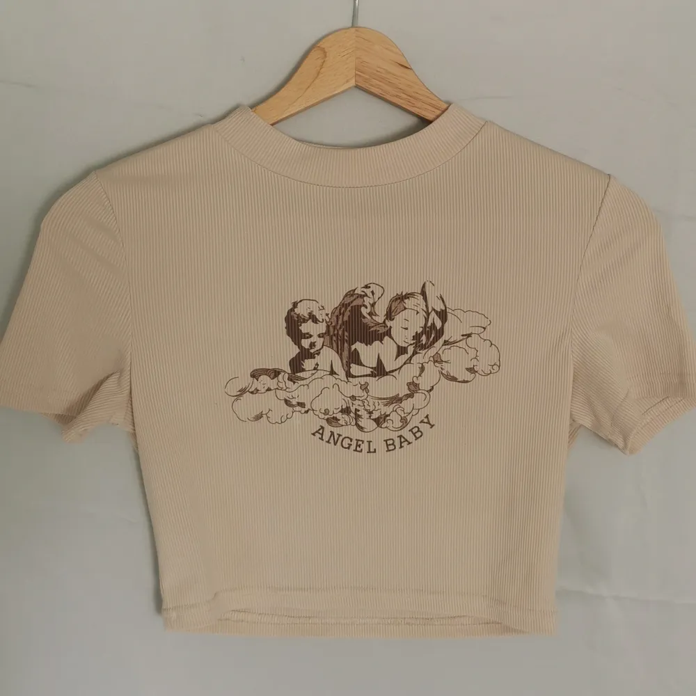 Säljer denna sjukt gulliga baby t-shirten med ett ängelmotiv på! . T-shirts.