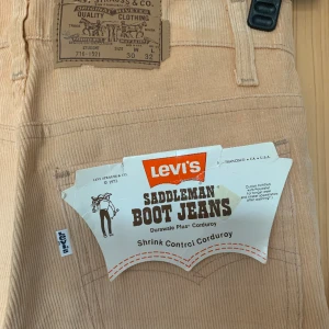 Beigea manchesterbyxor från Levi’s, retro! - Beiga manchesterbyxor från Levi’s, med lappen kvar! Riktigt coola men tyvärr för små för mig. Perfekt skick! Längd midja - ben 107cm Längd midja - gren 28cm Midja 36cm  Höft/stuss 42cm Innerben 79cm