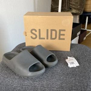 Yeezy slide - Säljer nu dessa extremt sköna yeezy tofflor. Tofflorna är i storlek 42 men är väldigt små i storleken så passar bättre 40-41. Om ni har några funderingar så är det bara att höra av er. Medföljer till köpet är är boxen.