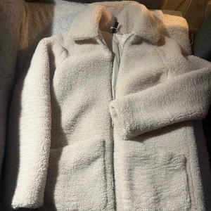 Jacka i Pile - En jacka i mjuk pile med krage. Endast använd en gång, som ny.