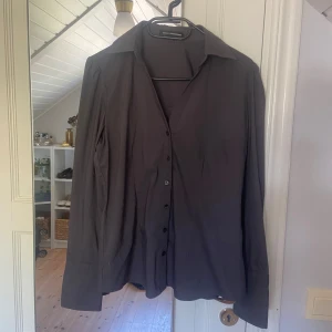 Figursydd skjorta  - Så fin figursydd skjorta med silverdetalj på ärmen, stl S