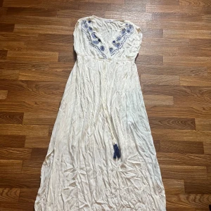 Klänning  - En vit klänning med blåa detaljer från bodyflirt. Storlek 42