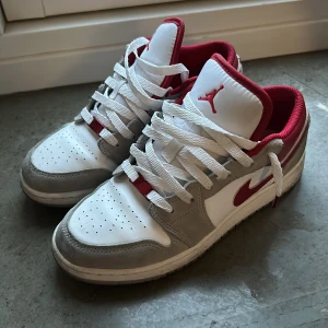 Nike Jordan 1 Low Se smoke Gray gym red - Knappt Använda. Vita skor med röda Och grå mocka detaljer.