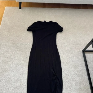 Ribbad klänning  - Svart ribbad klänning i midi längd. 